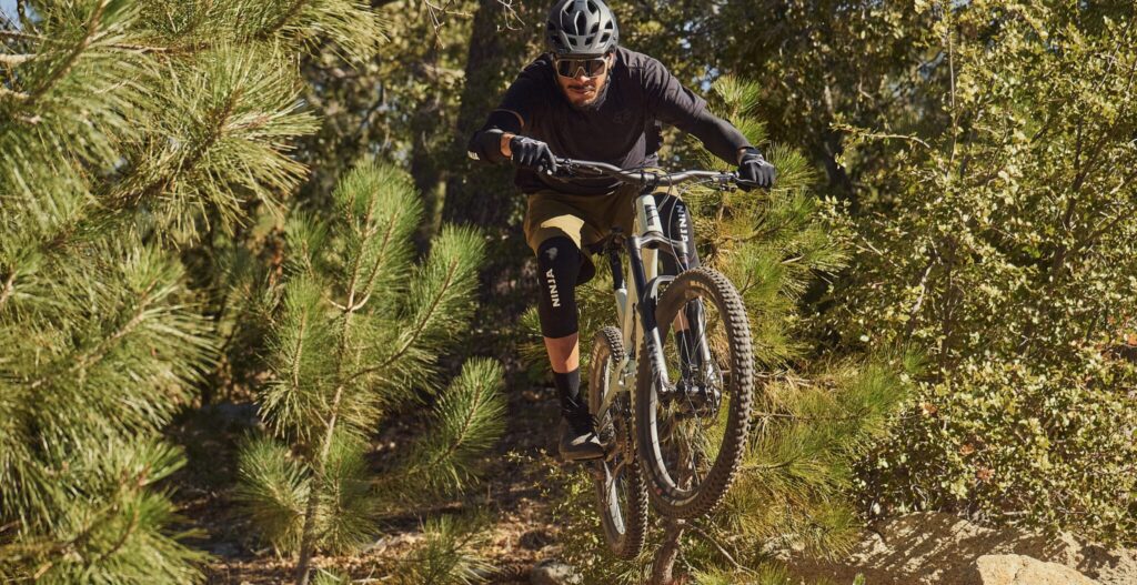 man jumping a bike wearing ninja pads