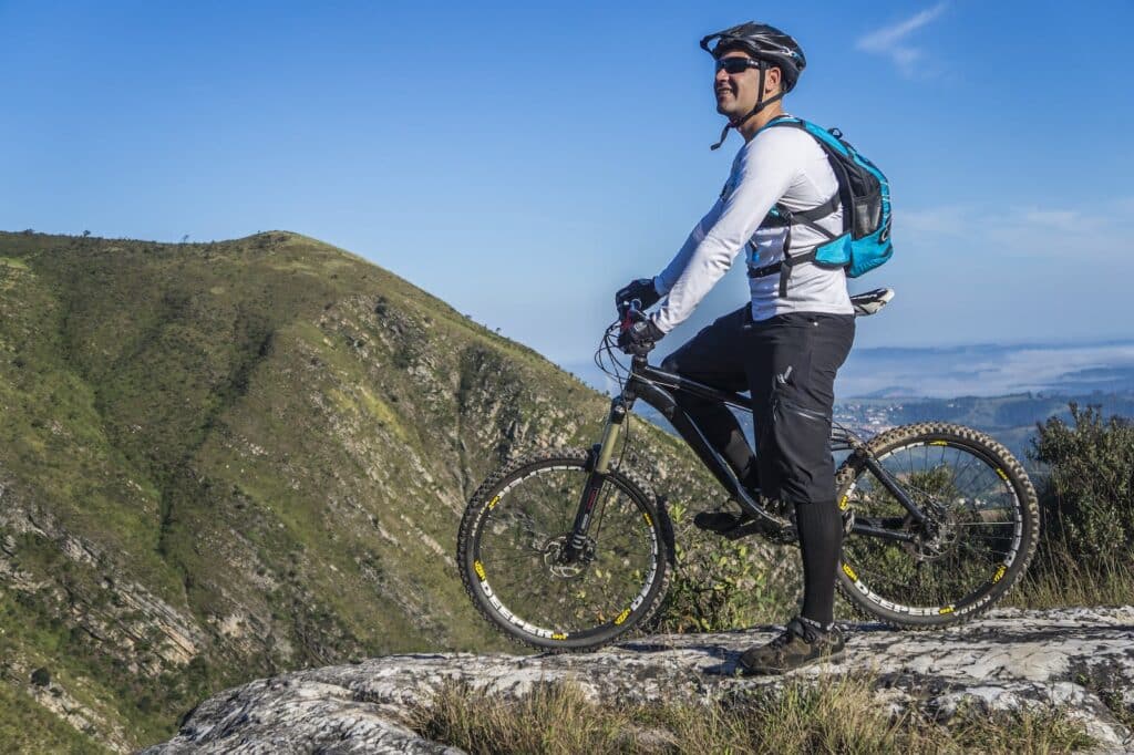 Man wearing a backpack sitting on a mountain bike
